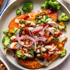 Baked sweet potato topped with chickpeas, broccoli, red onion and tahini sauce.