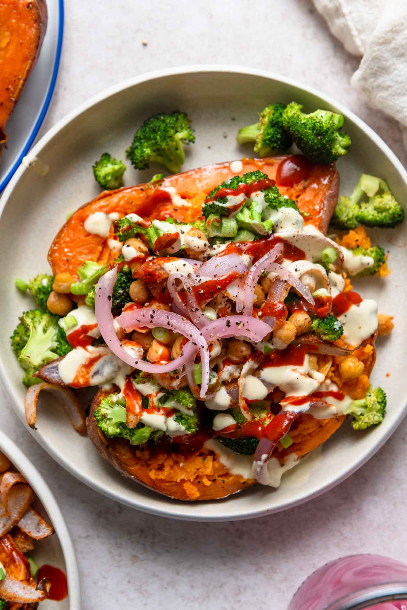 Baked sweet potato topped with chickpeas, broccoli, red onion and tahini sauce.