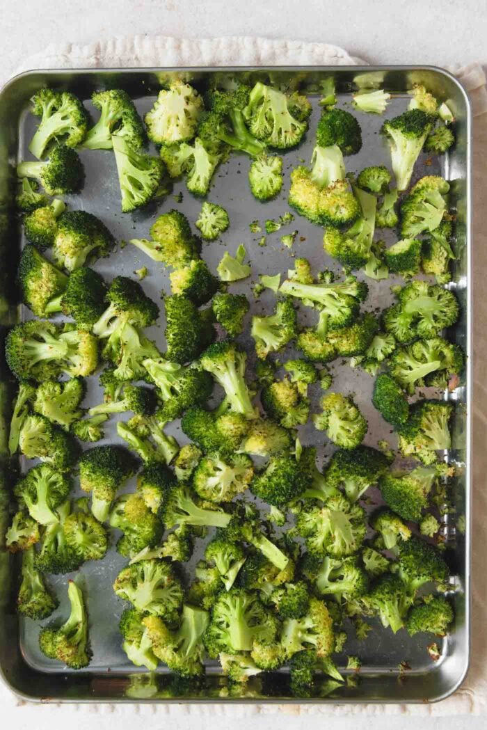 Roasted broccoli florets on a baking sheet.