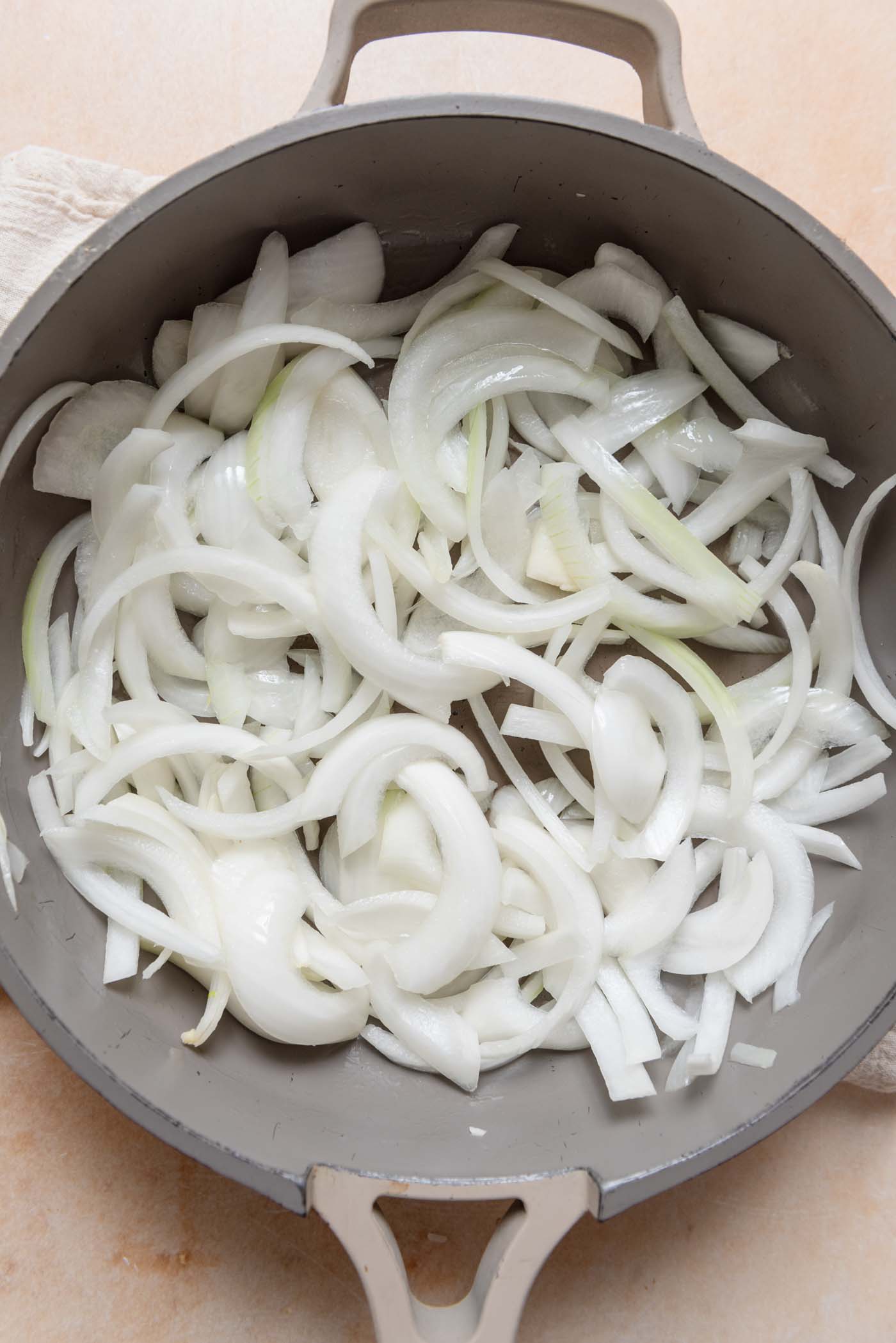 Sliced onions cooking in a pan.