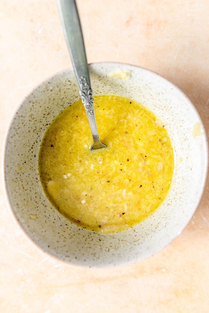Lemon dressing in a small dish with a spoon.