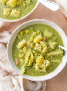 Bowl of soup with broccoli, cauliflower, white beans and potato.