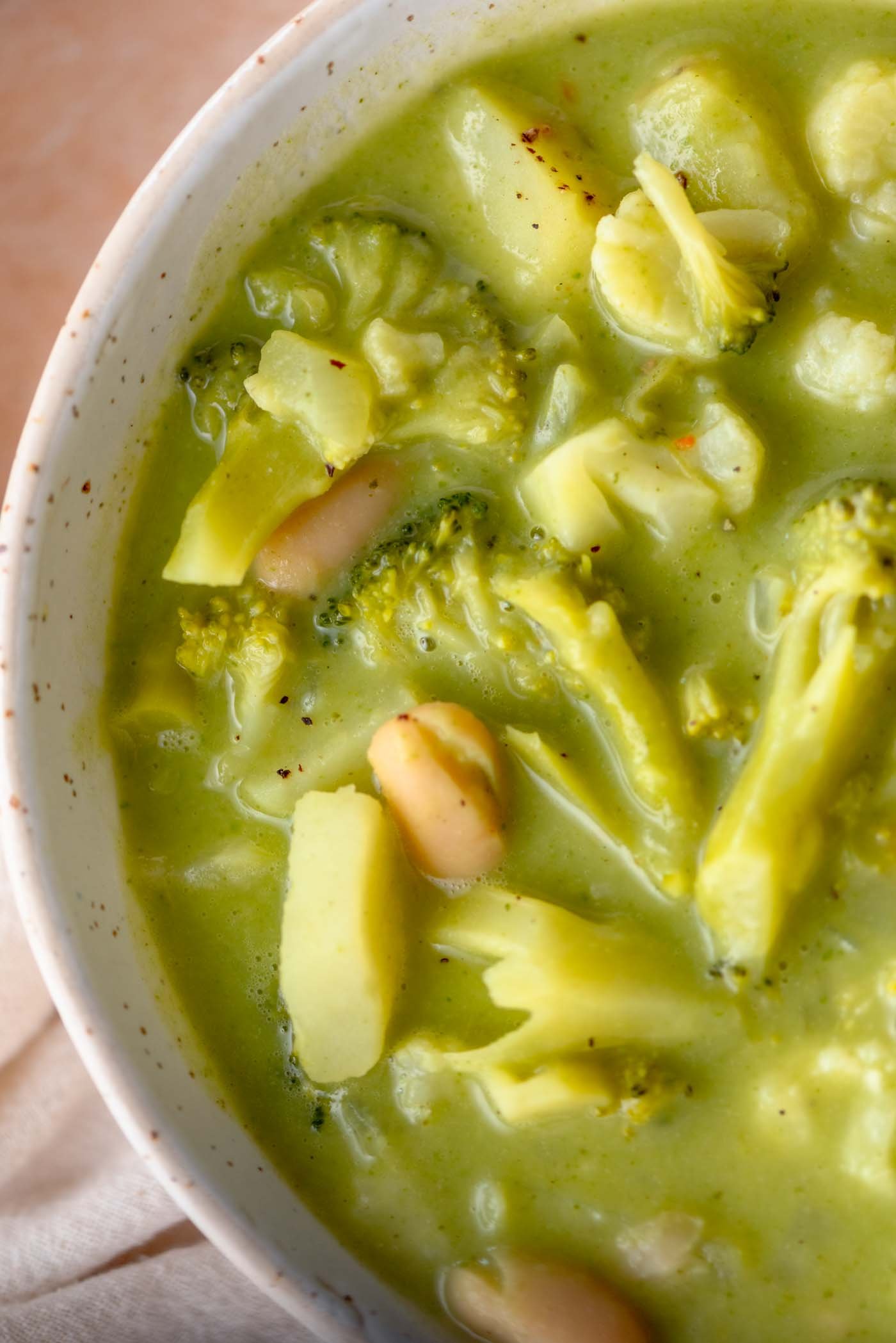 Bowl of broccoli, cauliflower, potato and white bean soup.