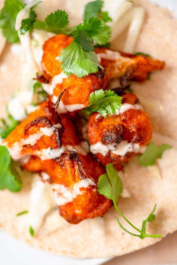 A buffalo cauliflower taco with cauliflower wings, ranch sauce and cilantro lime slaw.