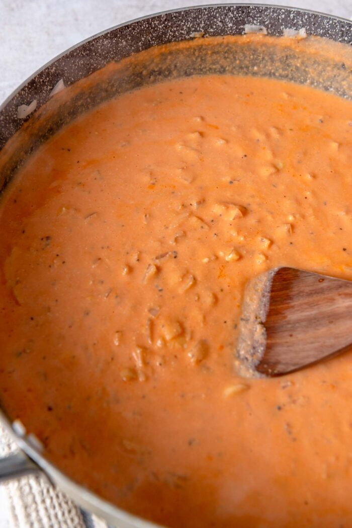 Creamy tomato sauce cooking in a large skillet.