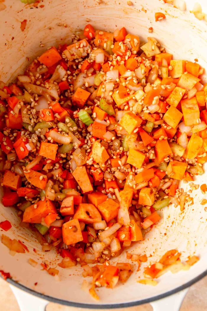 Sweet potato, barley, celery, onion and carrot cooking in a large pot.