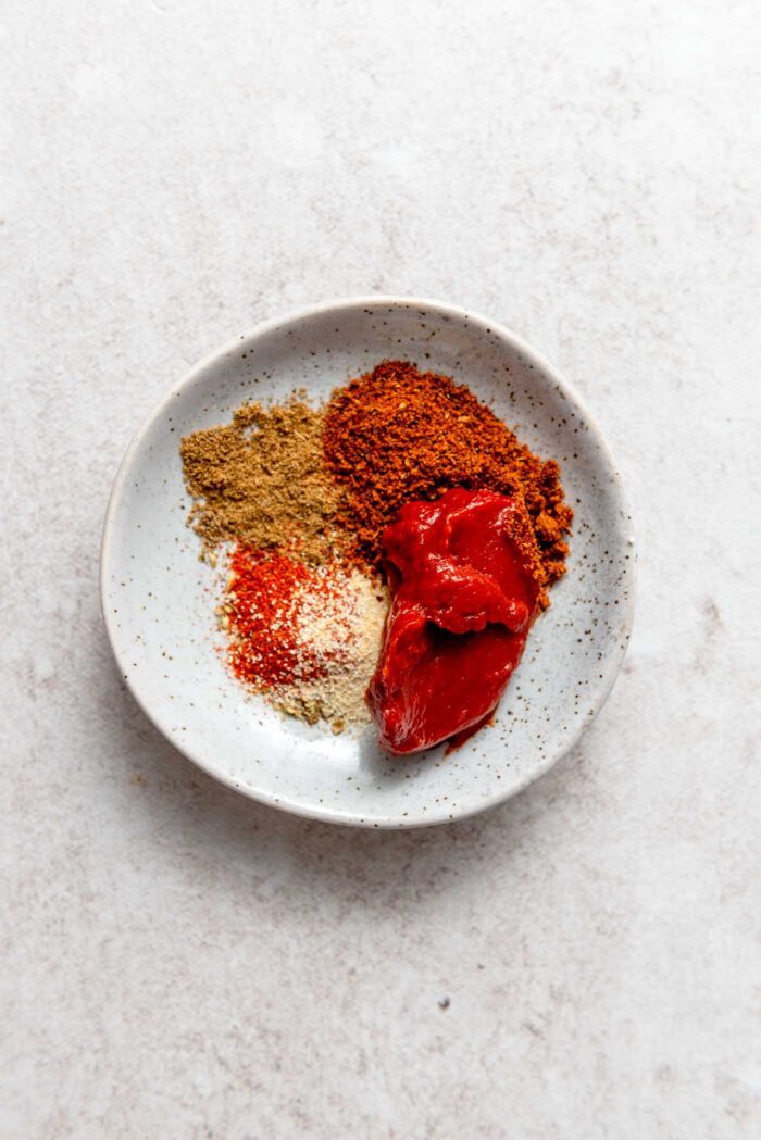 Taco spices and tomato paste in a small dish.