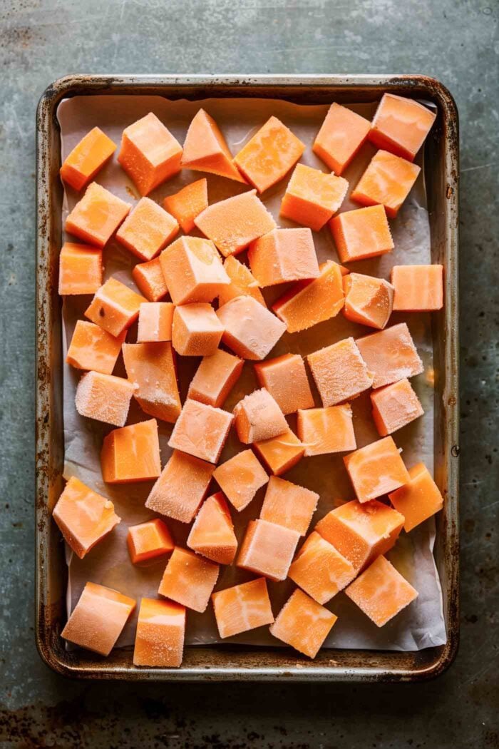 Chopped sweet potato cubes on a baking sheet.