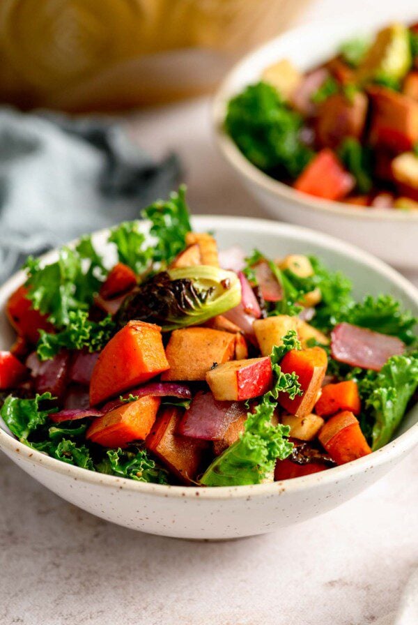 Roasted vegetable kale apple salad with sweet potato in a small bowl.