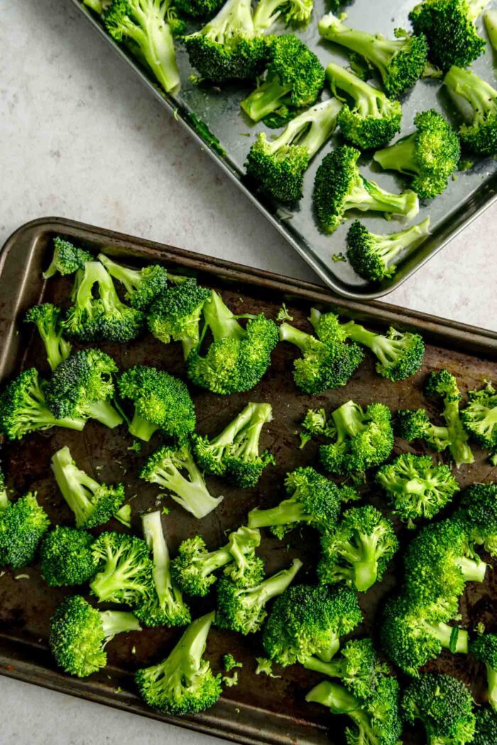 Broccoli florets on baking sheets.