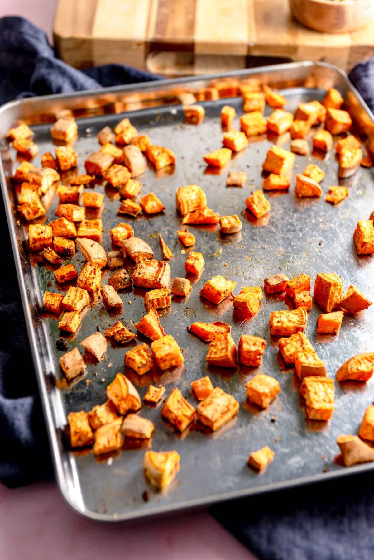 Roasted sweet potato cubes on a baking sheet.