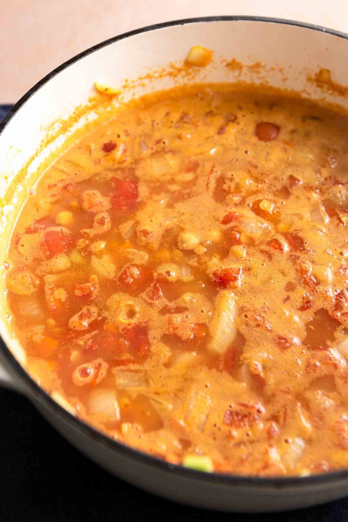 Curry lentil chickpea and tomato soup cooking in a large pot.