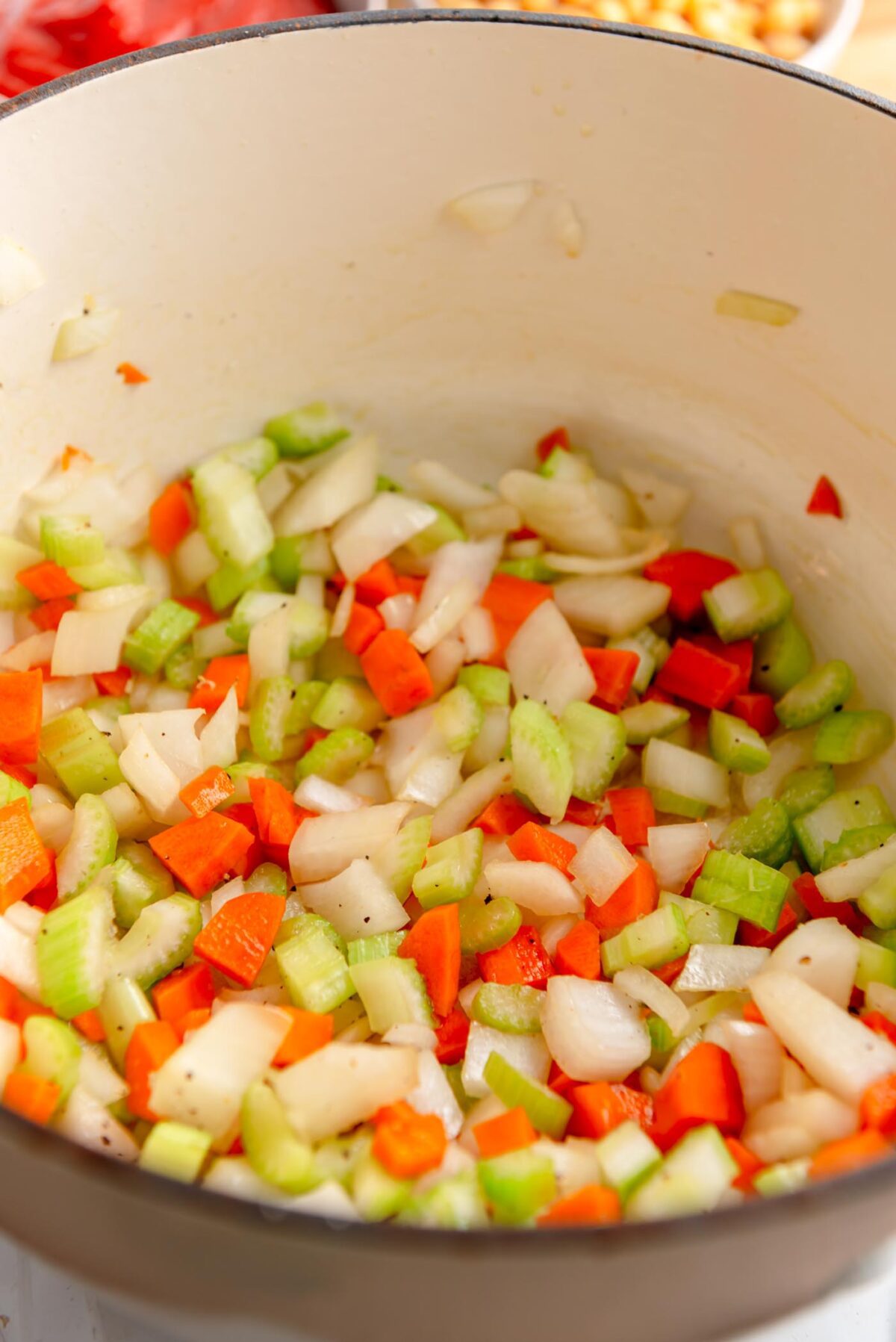 Carrot, onion and celery cooking in a soup pot.