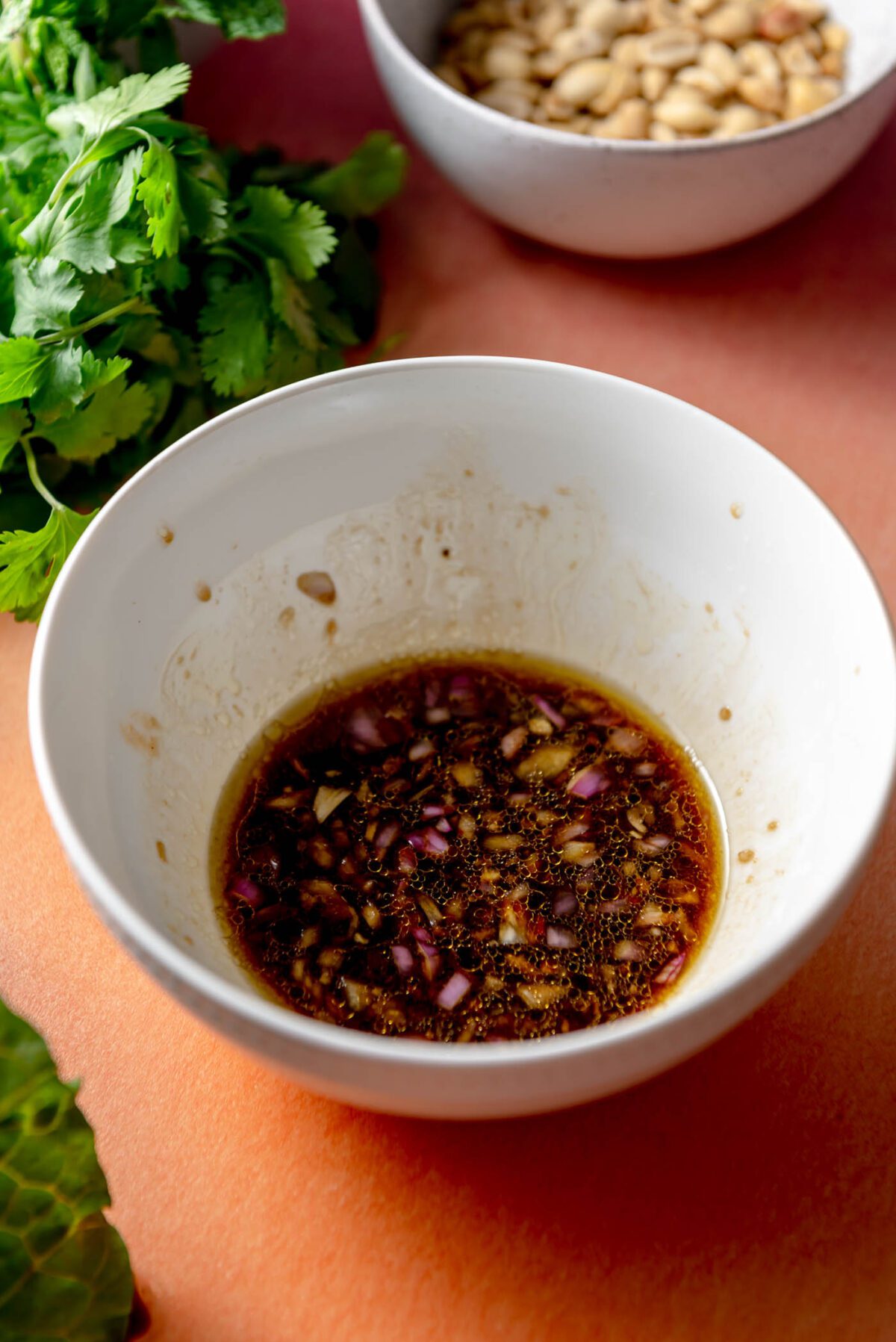 Salad dressing with chopped shallot and garlic in a small dish.