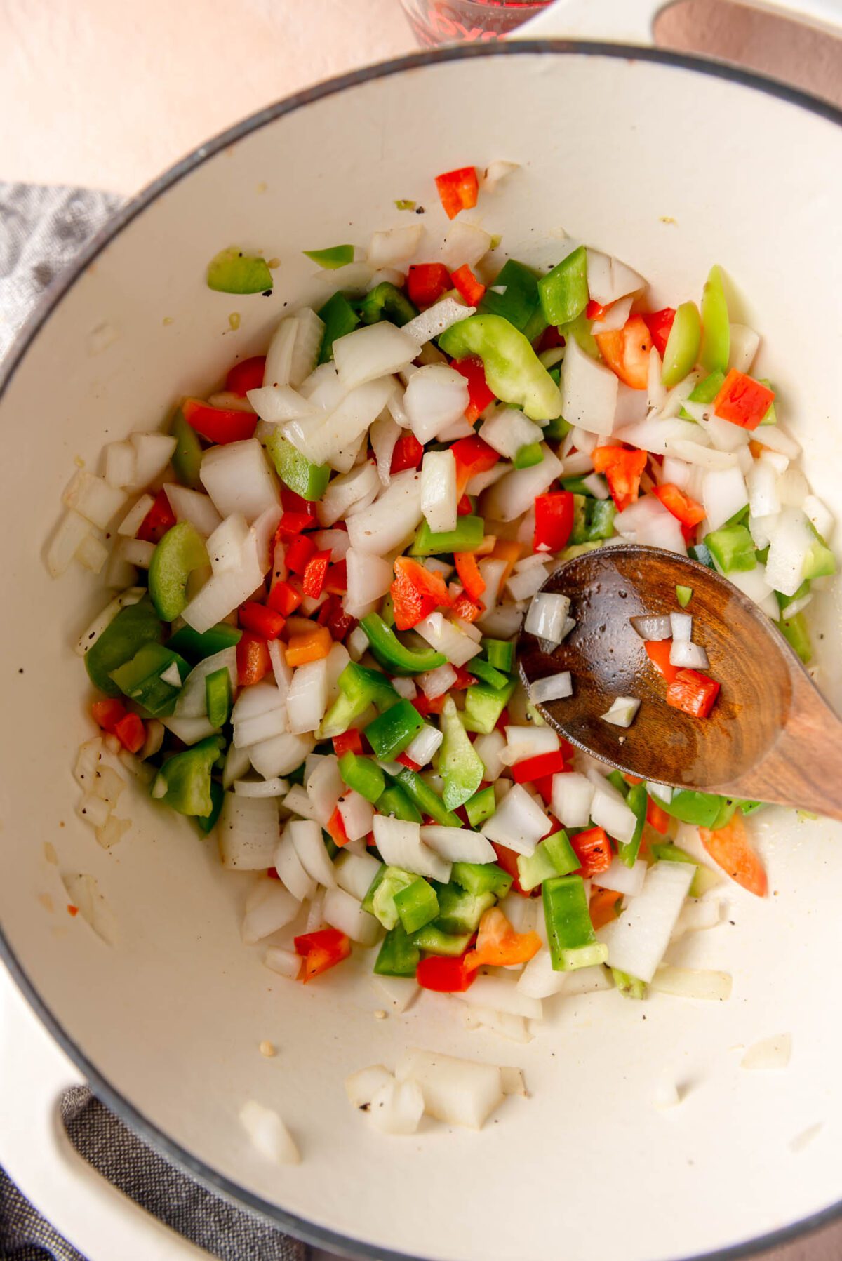 Diced onion and bell peppers cooking in large pot.