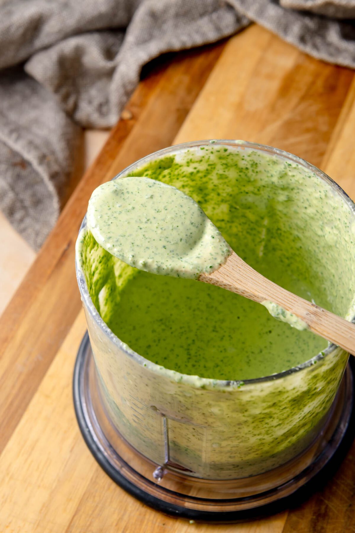 Creamy herb tahini sauce with parsley, cilantro, and lemon in a small blender jar.