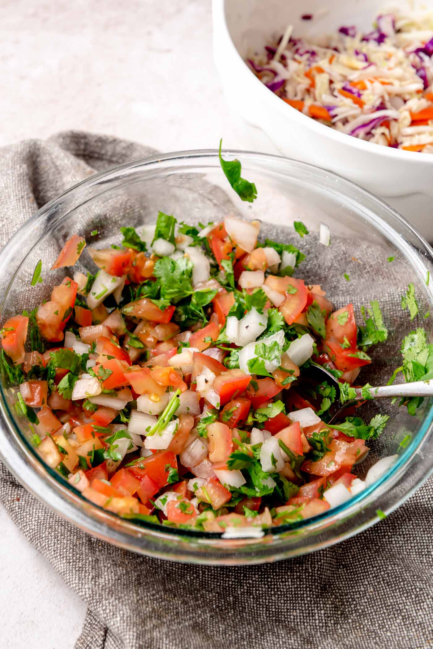 Fresh pico de gallo in a glass bowl with diced tomatoes, onions, and cilantro.