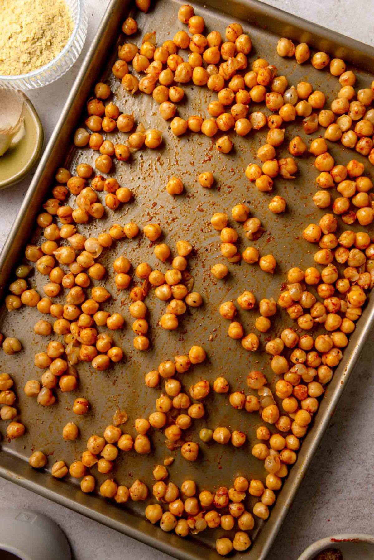 Roasted vegetable Caesar salad with crispy chickpeas, kale, broccoli, cauliflower, and pickled red onions in a creamy dressing, served in a shallow bowl.