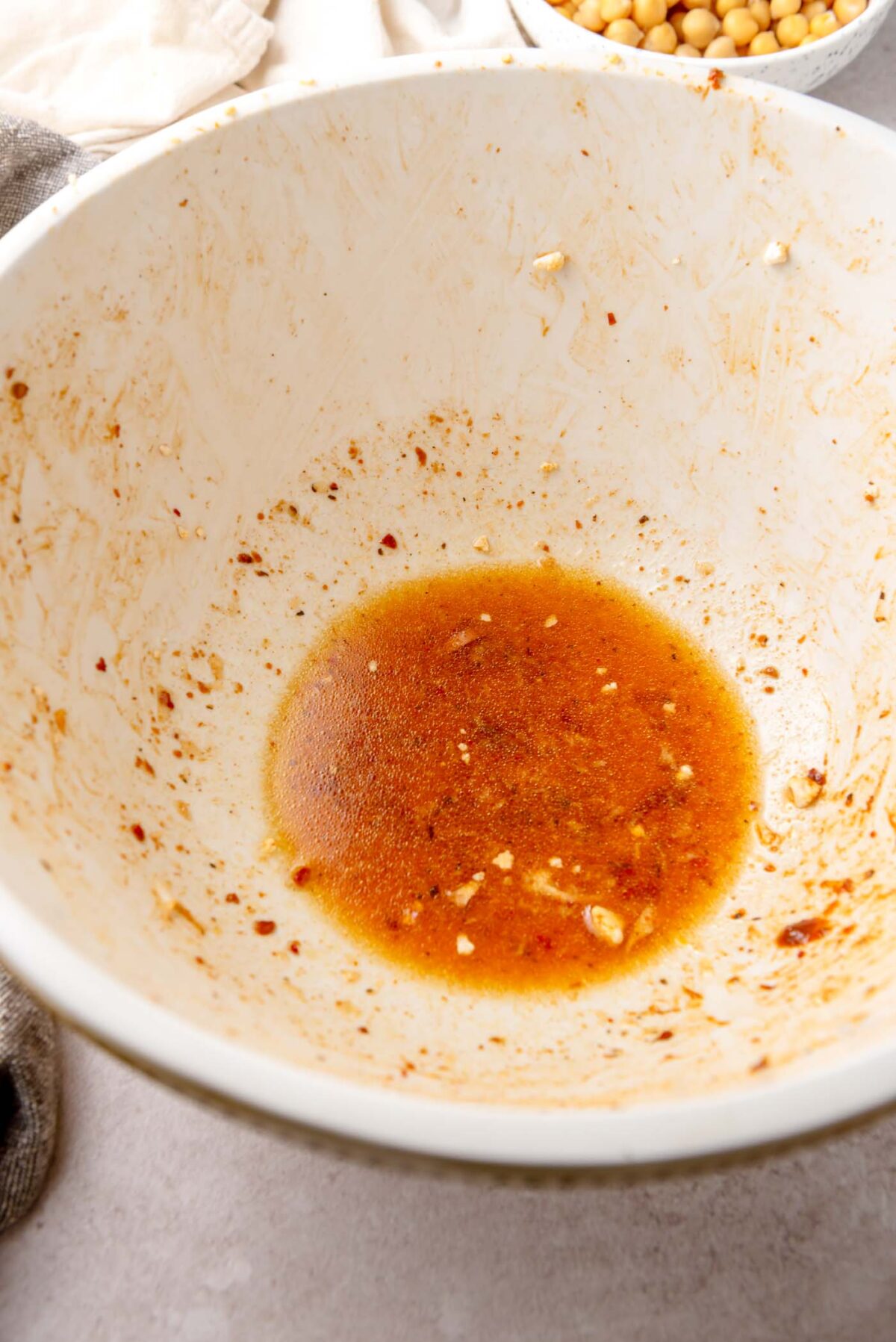 Small amount of dressing with oil, spices and garlic in a mixing bowl.